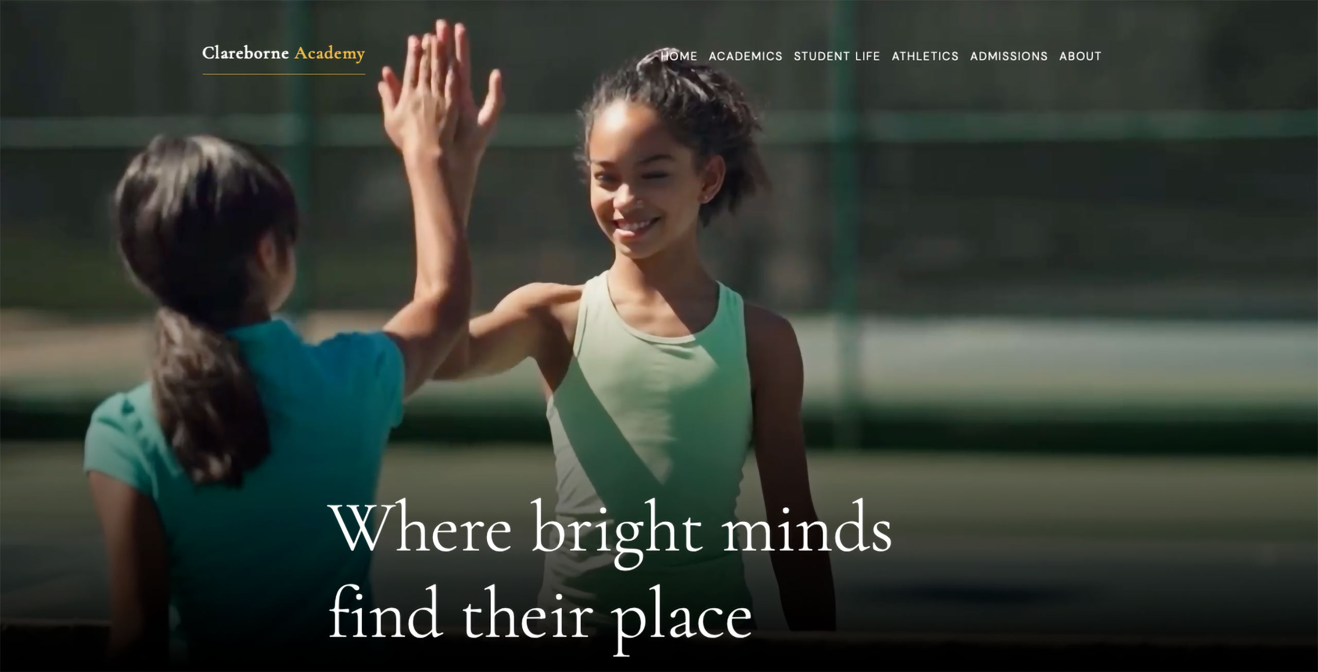 Two students high five each other during a tennis game. A still from a video hero on a demo school website with the brand and tagline: Clarebourne Academy, Where bright minds find their place